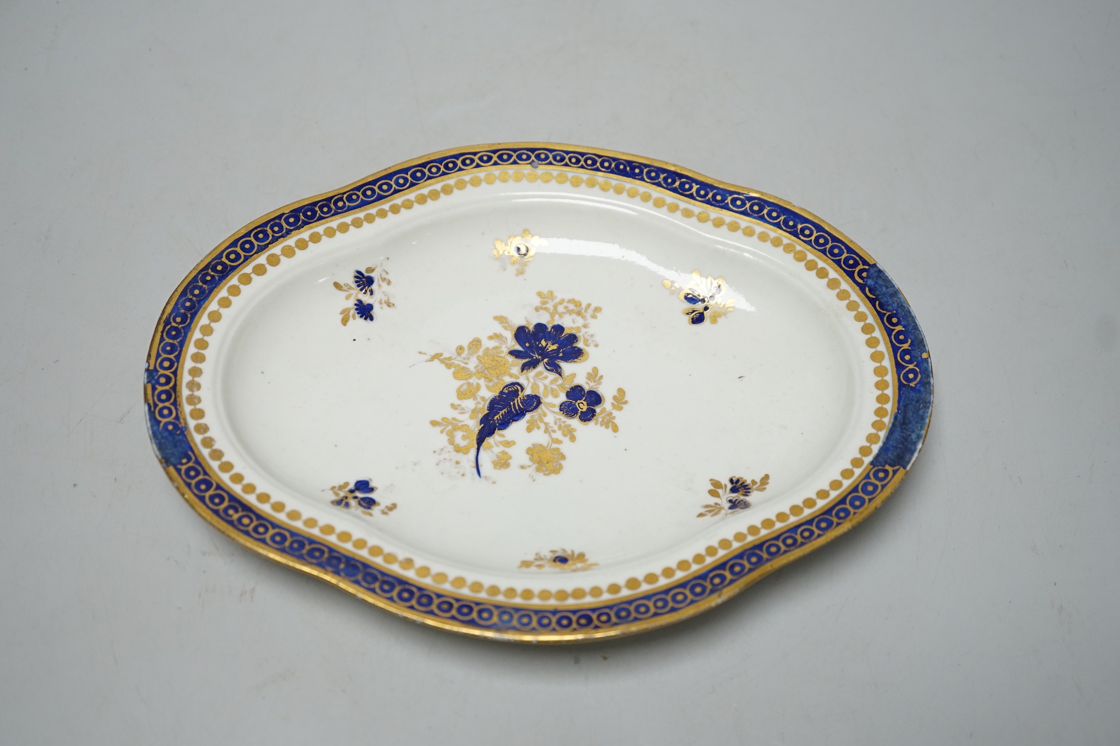 An 18th century Caughley tureen cover and stand with blue and gilt decoration, stand mis-fired to border, S mark to stand and base. 15cm wide